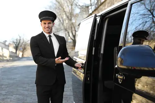 A chauffeur service car parked in front of a luxury hotel, ready to transport guests in style.