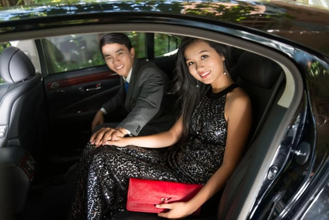 A woman sitting in a car, ready for prom. Experience luxury with our limo services for prom.
