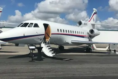 A Dassault Falcon 900B private jet with its door open and stairs extended, ready for the customer’s arrival—symbolizing executive aviation transport in Houston.