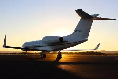 A Gulfstream G550 private jet on the airport runway, beginning its takeoff roll, symbolizes luxury private jet and car service in Houston.