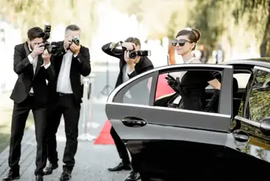 Capture unforgettable moments with friends as a woman takes pictures near a group by a car. Experience elegance and make memories with us.