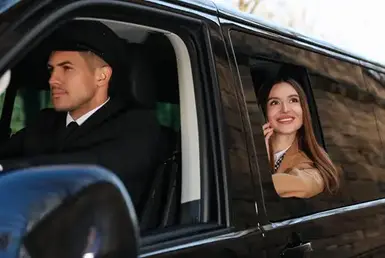 Professional driver and businesswoman in luxury car. Chauffeur service