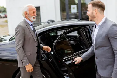 Corporate chauffeur service Houston with professional driver assisting executive client arrival