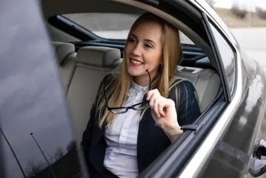 Elegant woman in the back of a black luxury sedan, symbolizing Executive Chauffeur Service in Houston.
