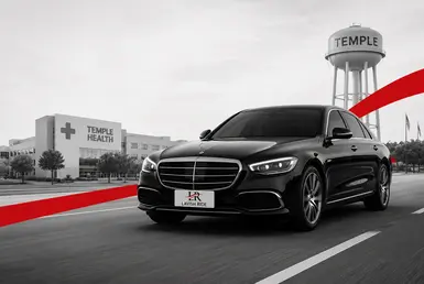 Black Mercedes E-Class providing medical transportation to Temple with Lavish Ride branding and healthcare facilities in the background.