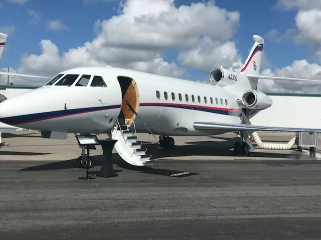 A Dassault Falcon 900B private jet with its door open and stairs extended, ready for the customer’s arrival—symbolizing executive aviation transport in Houston.
