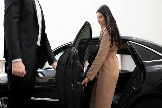 woman getting in a Black car service